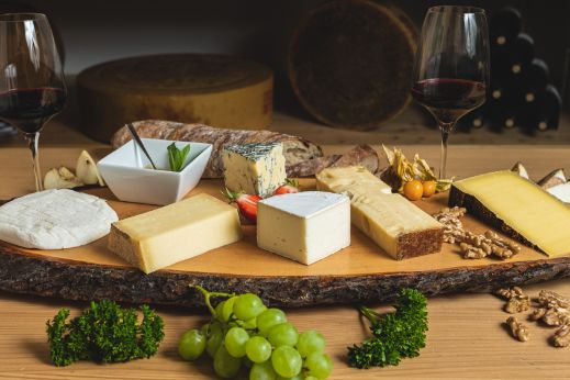 Eine Variation von Käse mit Schweizer Herkunft, passender Wein, Brot und Früchte. Diese Käseplatte ist bei Chäsbueb erhältlich.