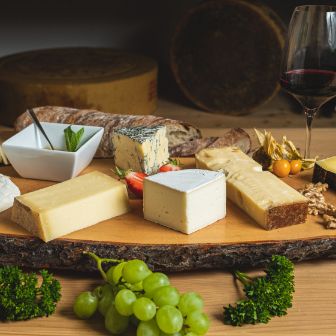 Eine Variation von Käse mit Schweizer Herkunft, passender Wein, Brot und Früchte. Diese Käseplatte ist bei Chäsbueb erhältlich.